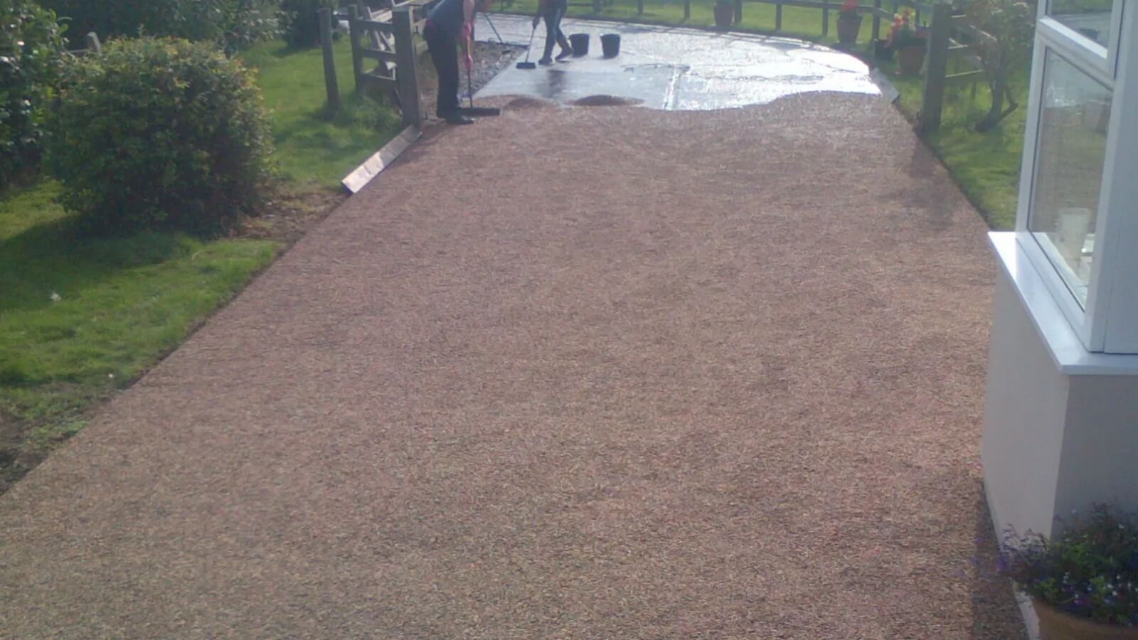 Stone chippings being spread during tar and chip installation