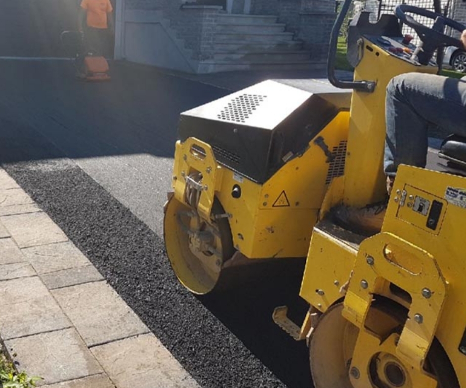 Tarmac wearing course being rolled to a smooth finish on a driveway